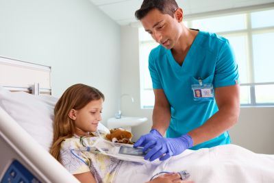 Clinician checking the Telemetry Monitor 5500 at the bedside with pediatric patient
