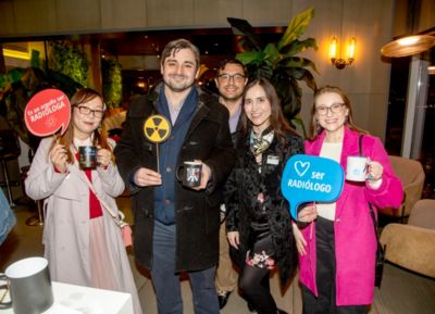 Radiologists holding signs celebrating radiology profession at Philips Chile event