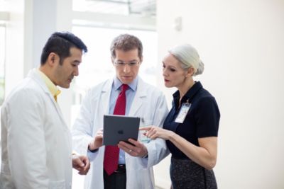 Healthcare administrators discussing data on a tablet