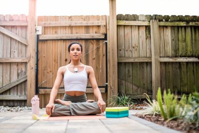 Kvinna som utövar yoga utomhus med bärbar hjärtövervakningspatch