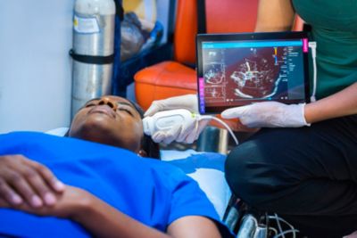 Clinician performing ultrasound exam using Philips Lumify device on patient in care setting