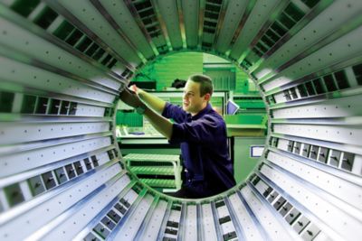Engineer assembling components of a Philips MRI scanner in manufacturing facility