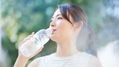 運動後に屋外で水を飲む女性