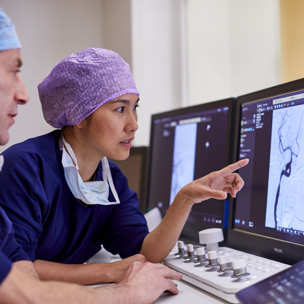 Two medical professionals reviewing images on monitor