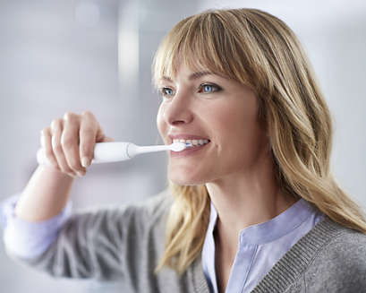 A patient using a Philips Sonicare power toothbrush at home