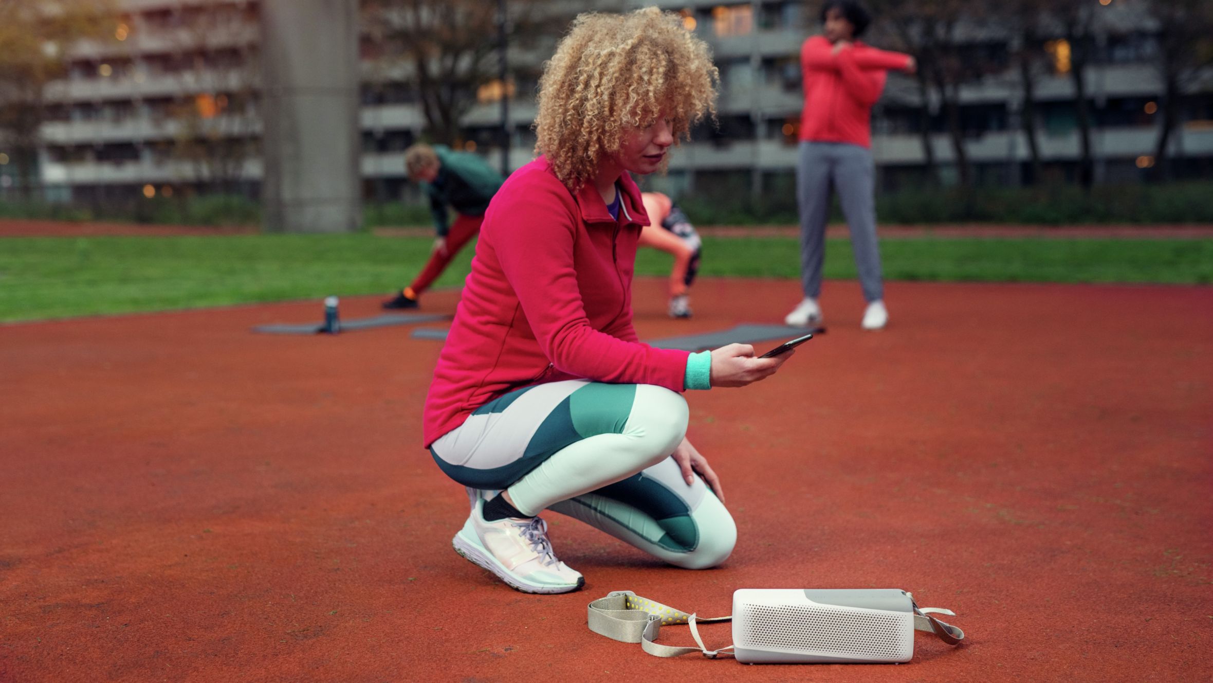 Žena se povezuje s Philips bluetooth zvučnikom na otvorenom