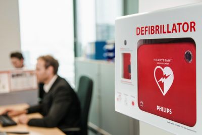 Automated external defibrillator mounted on wall in office environment
