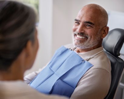 A patient smiling from a dental chair.