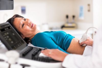 Vrouw ondergaat een echografisch onderzoek van de buik met de Philips Affiniti 800