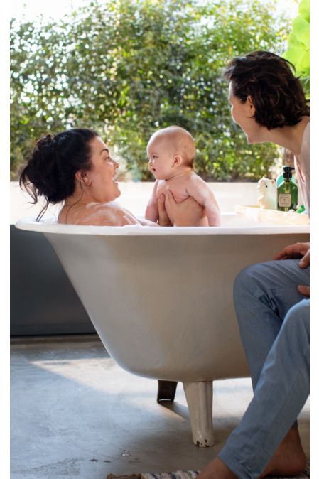Bebé en la bañera con dos mujeres