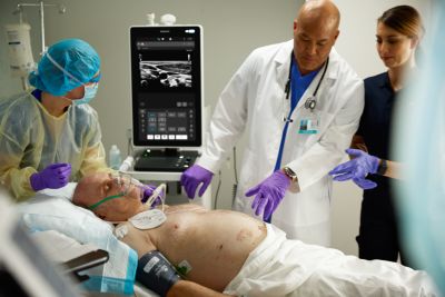 Patient in emergency medicine scene with clinicians overseeing care