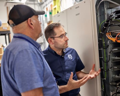 Mechanicians chatting over the insides of a machine