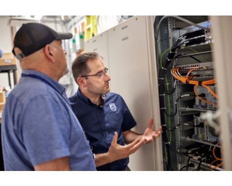 Mechanicians chatting over the insides of a machine