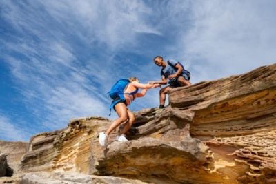 Two people climbing a rock