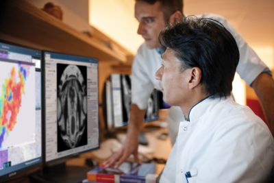 Profesionales médicos revisando imágenes de patología y diagnóstico en múltiples monitores
