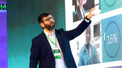 Speaker presenting digital health data on large screen during healthcare conference