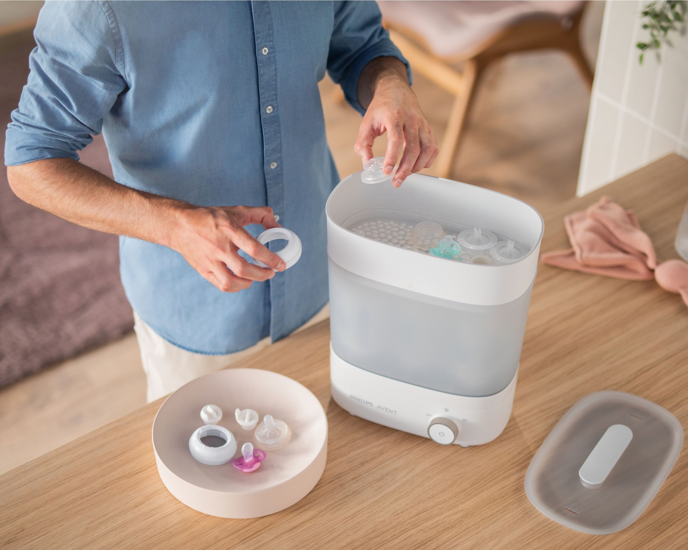 Man putting bottles and pacifiers into the sterilizer