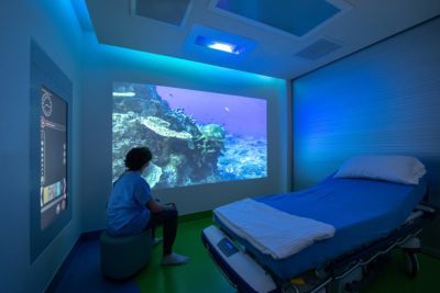 Pediatric patient viewing calming underwater video in Ambient Experience room