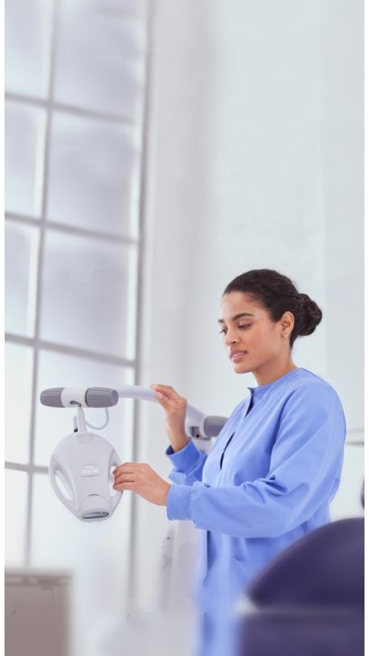 Un professionnel de la santé bucco-dentaire qui ajuste une lampe Philips Zoom!