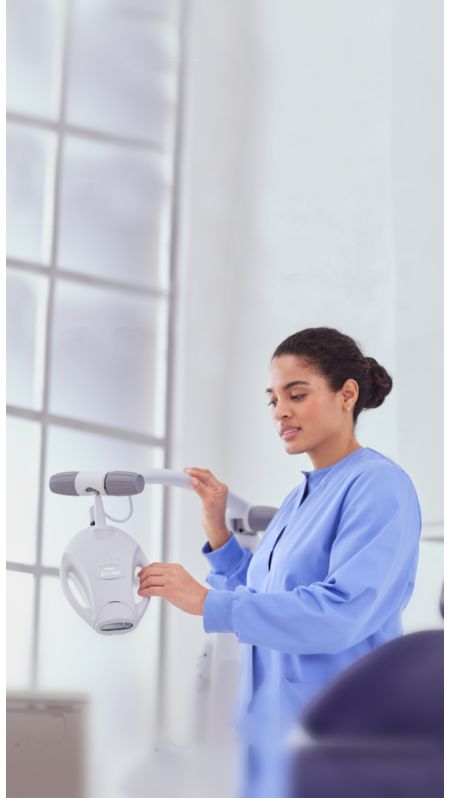 A dental professional adjusting Philips Zoom! WhiteSpeed lamp 