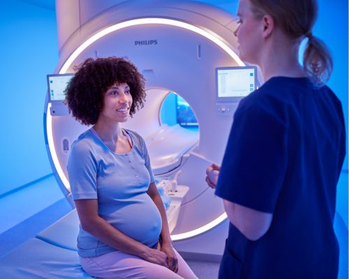 Technologist comforting patient prior to an MRI exam with Philips Ambient Experience.