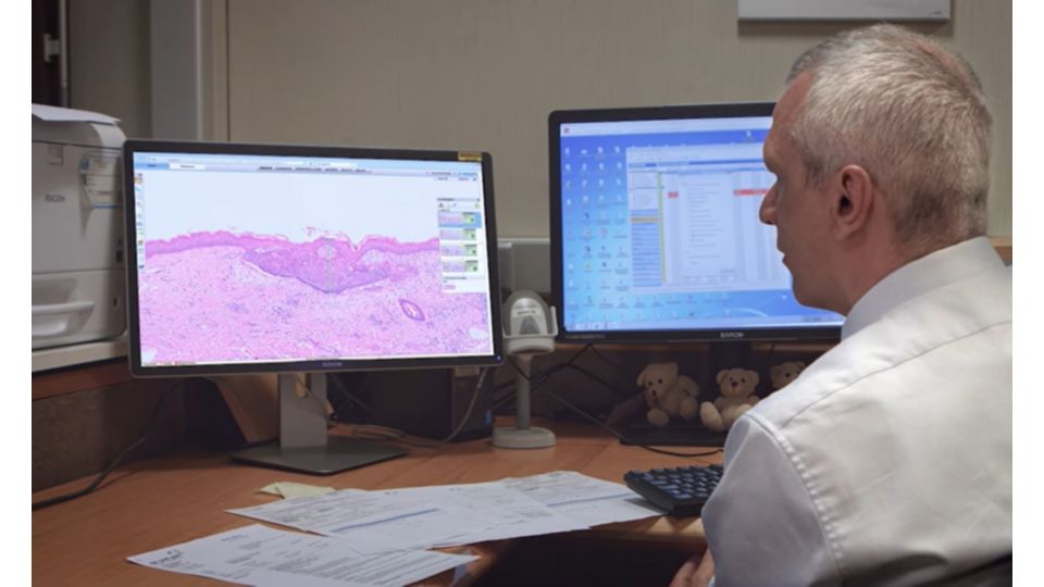Pathologist evaluating a digital pathology case on a desktop monitor
