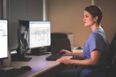 Clínico revisando dados de estudo do sono no software Philips Somnolyzer em uma estação de trabalho