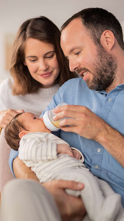 Parents feeding their baby with a baby bottle