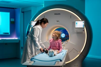 Paciente pediátrico siendo examinado por un profesional médico con un sistema de resonancia magnética de Philips