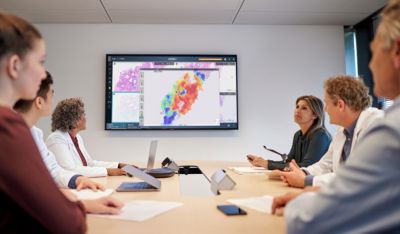 Zorgprofessionals analyseren digitale pathologiebeelden in een vergaderruimte met de Philips IntelliSite Pathology-oplossing