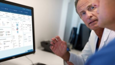 Clinicians discussing data on screen in a medical setting