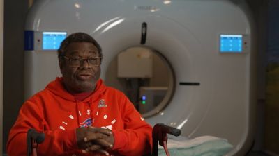 Lung cancer screening patient seated in front of mobile CT scanner