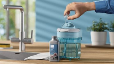 Philips Fleckenentferner wird in einen Wassertank gegossen