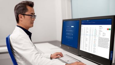 Un profesional médico revisa los datos del paciente en la plataforma de informática médica de Philips utilizando monitores duales