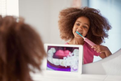 Child using Philips Sonicare electric toothbrush