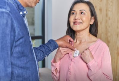Person applying Philips ePatch wearable cardiac monitoring device to a patient’s chest