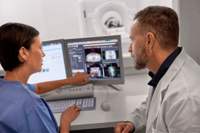 Médico y técnico operan un escáner de TC Philips desde la sala de control