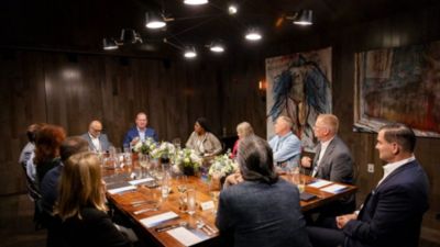 Group of healthcare leaders seated around table in discussion