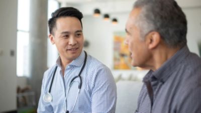 Doctor speaking with older patient during consultation
