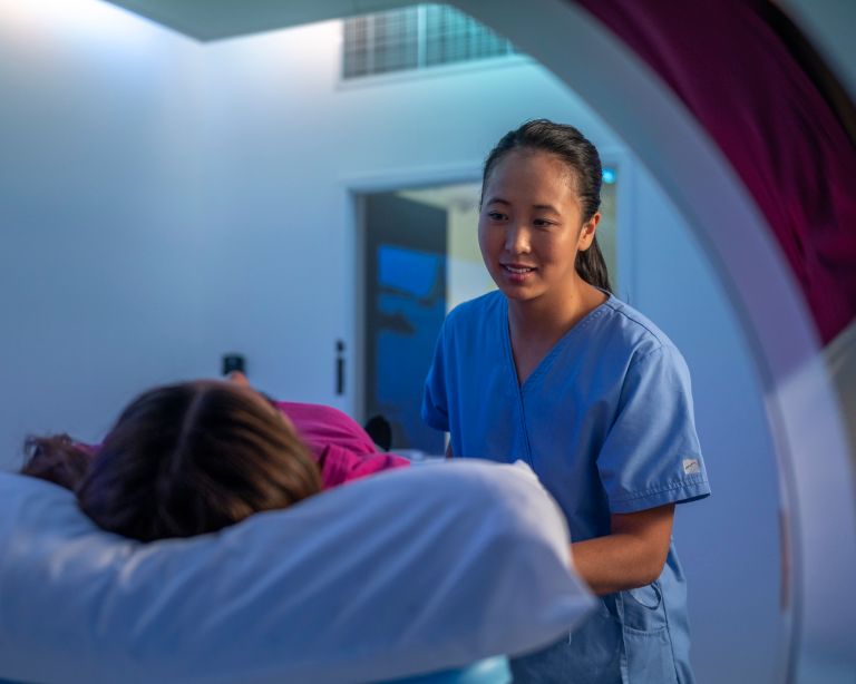 Female tech with patient in CT scanner 