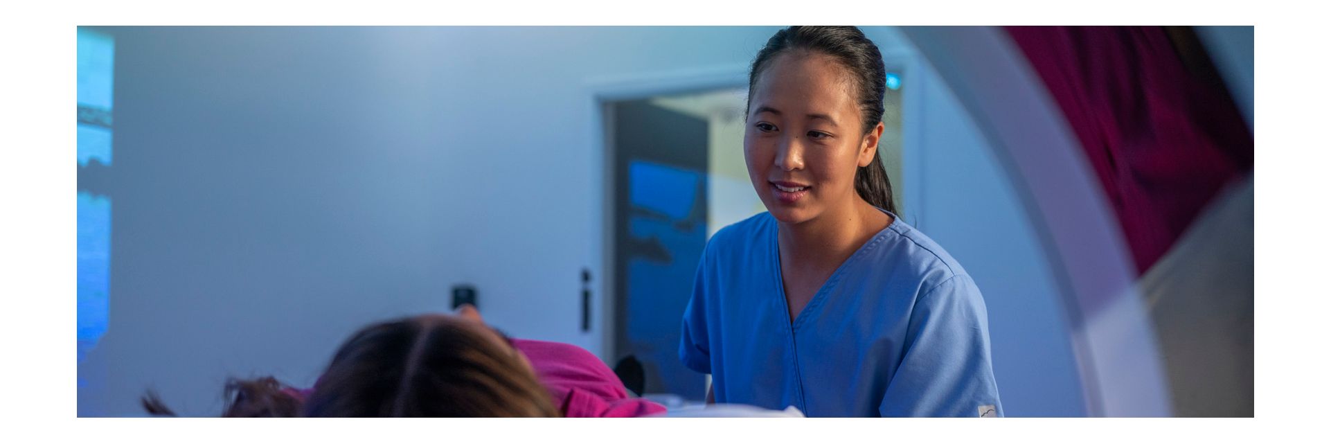 Female tech with patient in CT scanner
