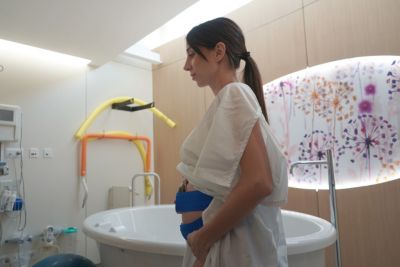 Pregnant woman wearing wireless fetal monitoring belt in birthing room