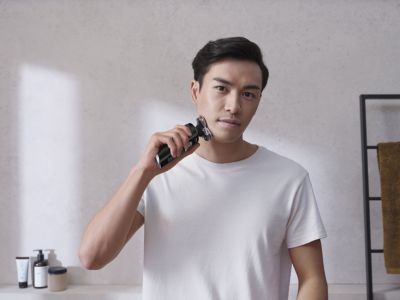 バスルームでフィリップスS9000で男性の髭剃り