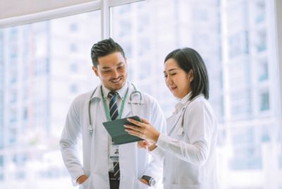 Clinicians review patient information on a tablet in a hospital setting