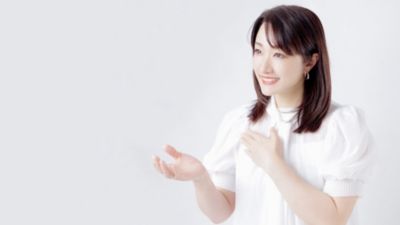 白い衣装で歯科治療のヒントを説明する歯科医