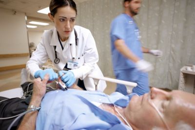 Un médico examinando a un paciente en el pasillo de un hospital durante una situación de atención de emergencias.