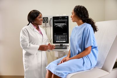 MSK clinician consulting with patient in front of mobile ultrasound system