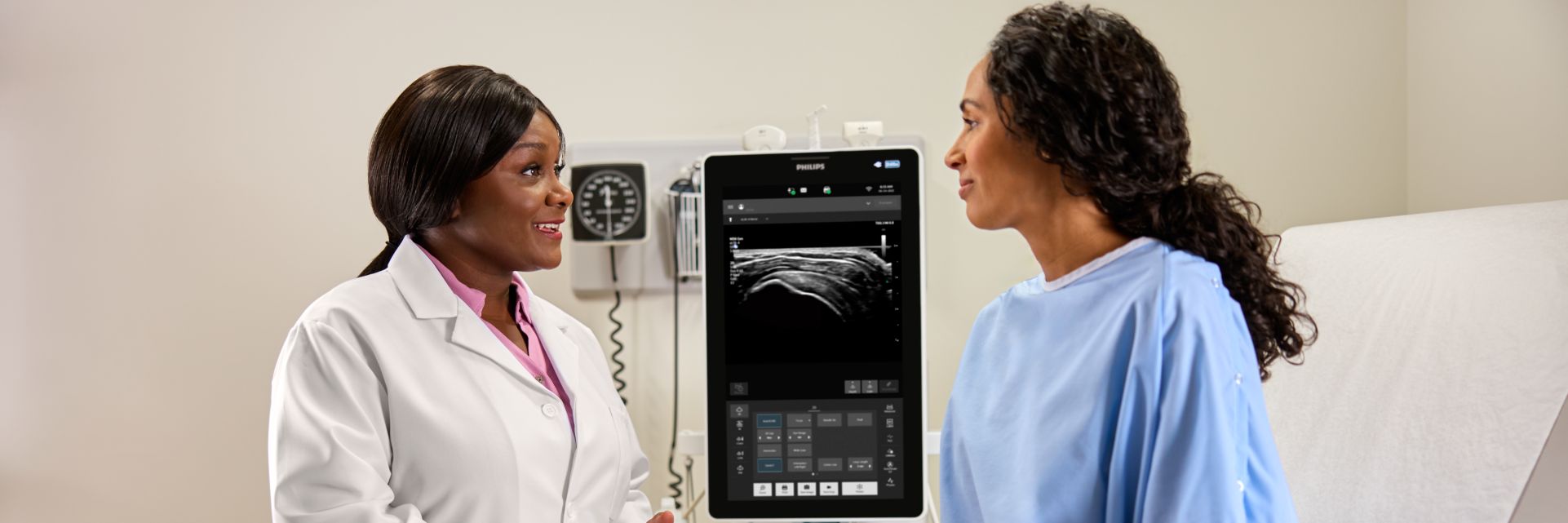 MSK clinician consulting with patient in front of mobile ultrasound system