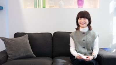 ソファに座り、ソニッケアー電動歯ブラシを手に