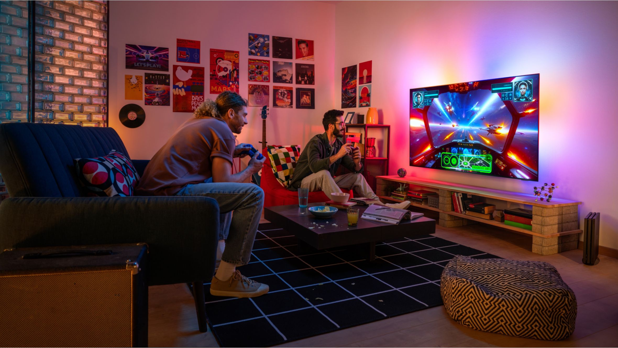 Deux personnes jouant &agrave; un jeu vid&eacute;o sur un t&eacute;l&eacute;viseur Philips Ambilight dans un salon color&eacute; et chaleureux.
